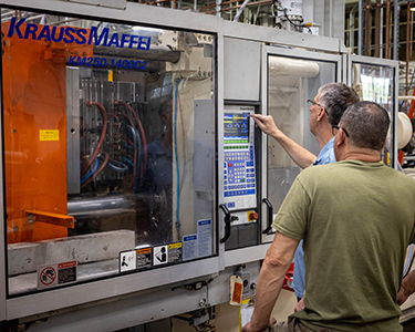 Two-IMT-employees-starting-production-on-a-machine